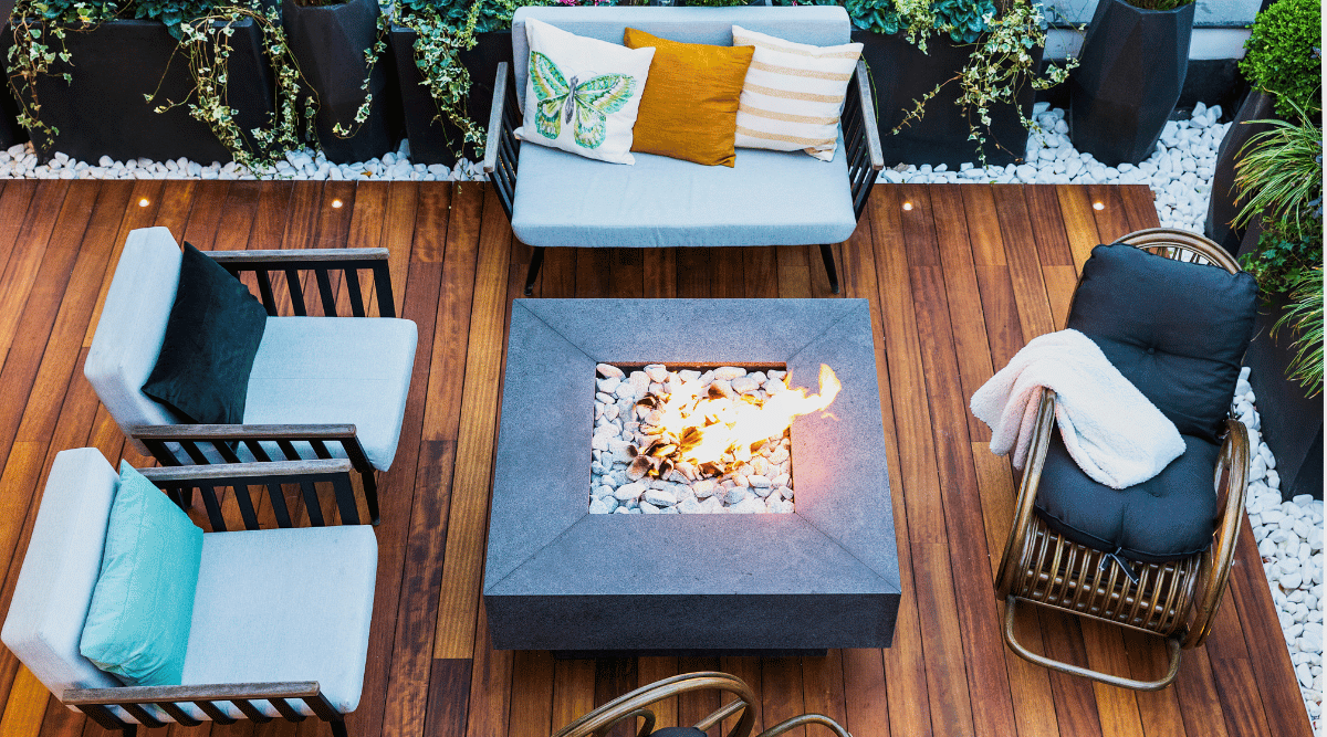 Backyard patio lounging furniture around a fire pit.
